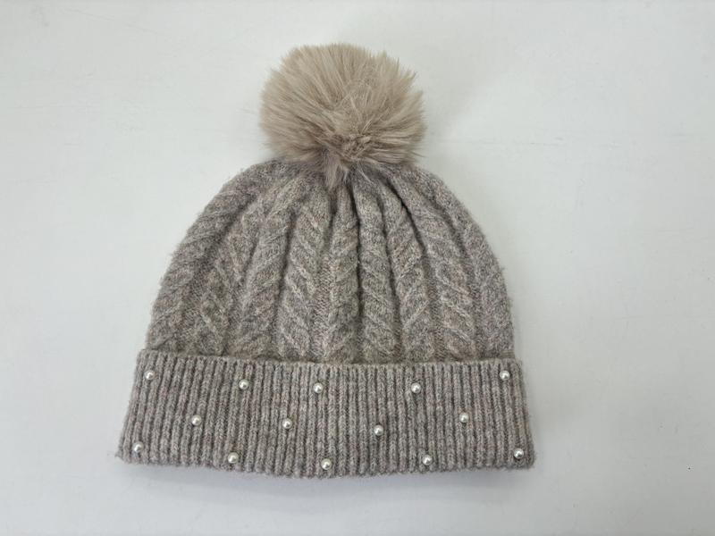 Grijze gebreide wintermuts met nepbont pompon en parelversiering langs de geribbelde rand.