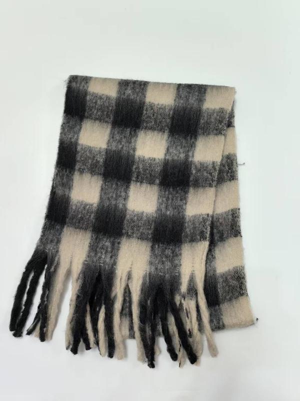 Gevouwen zwart-witte buffelruit wintersjaal met franjes op witte achtergrond.