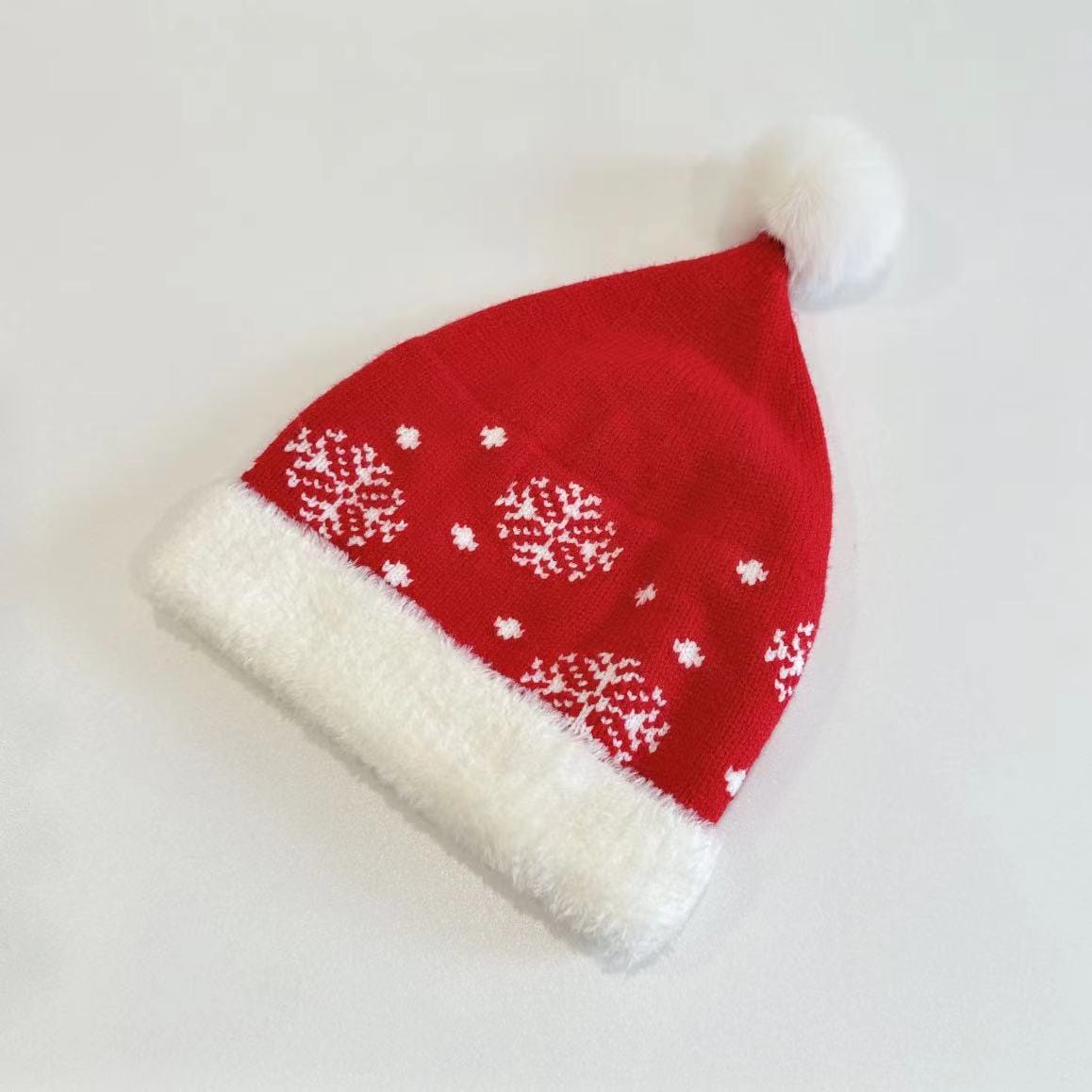 Rode gebreide kerstmuts met witte sneeuwvlokken