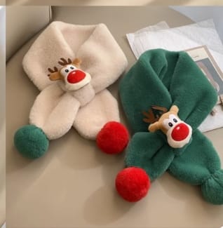 `Crème en groene pluche kindersjaal met rendierprint en rode pompons aan de uiteinden.`