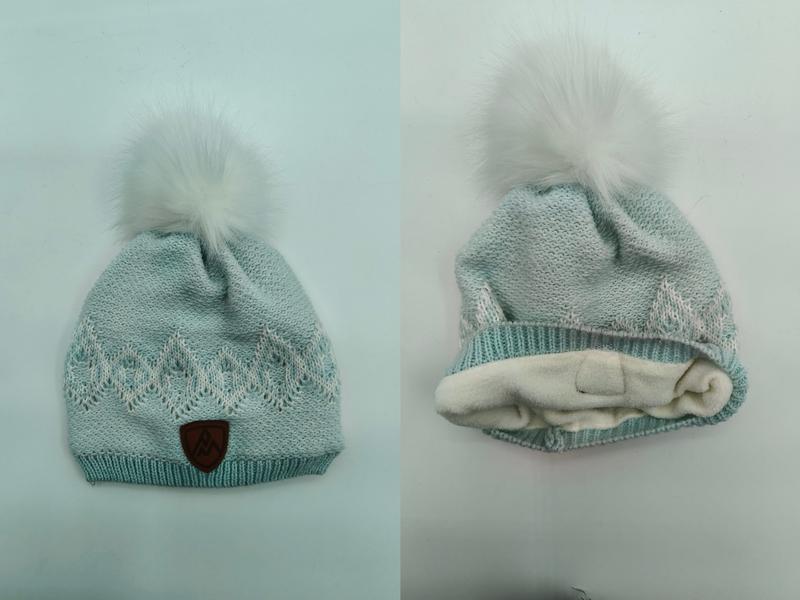 Mintgroene gebreide wintermuts met witte nepbont pompon