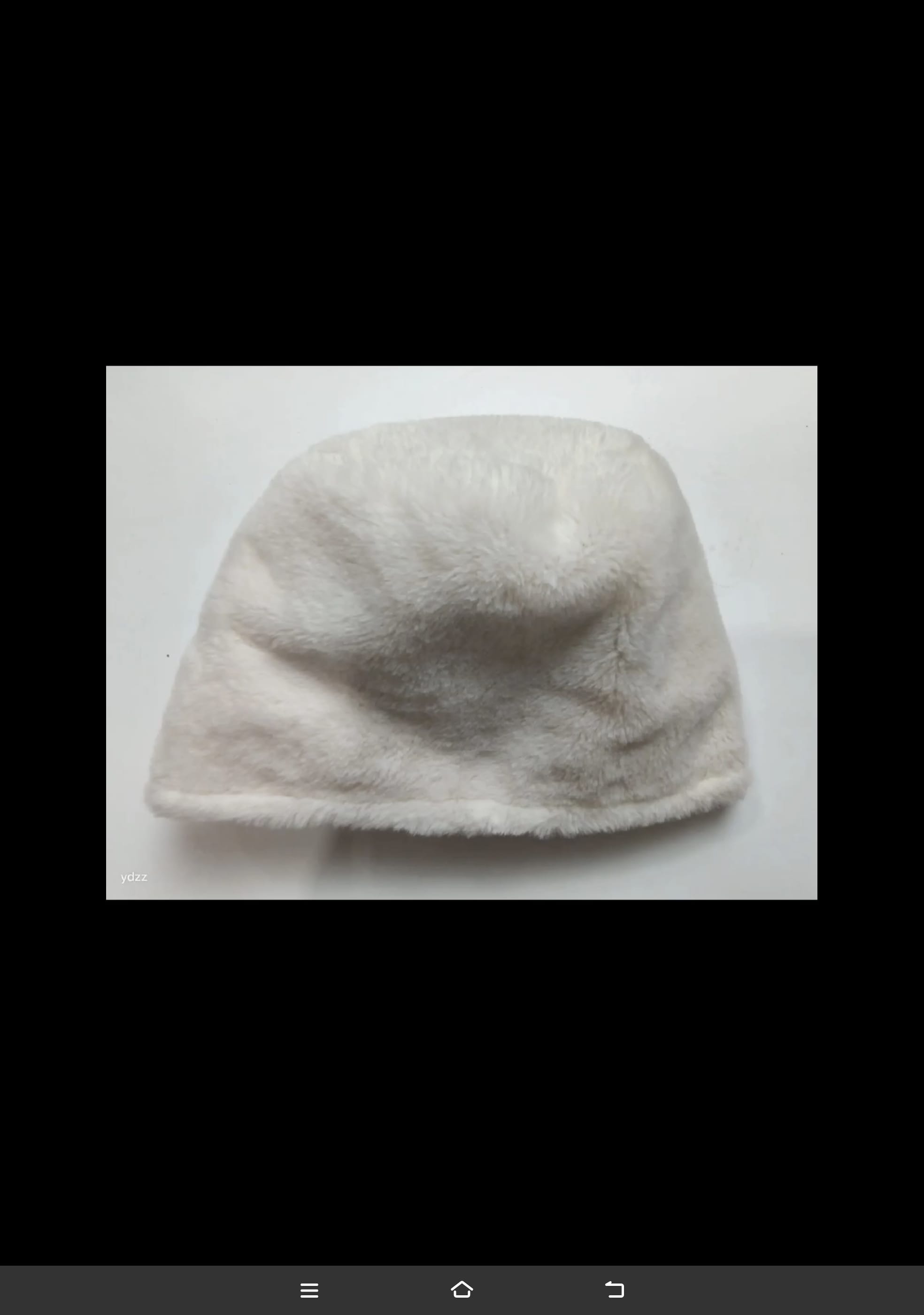 Crèmekleurige nepbont bucket hat plat neergelegd op witte ondergrond