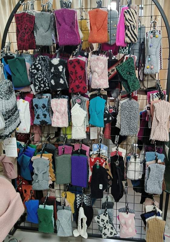 Groot winkelrek vol gebreide vingerloze handschoenen en wanten in diverse kleuren