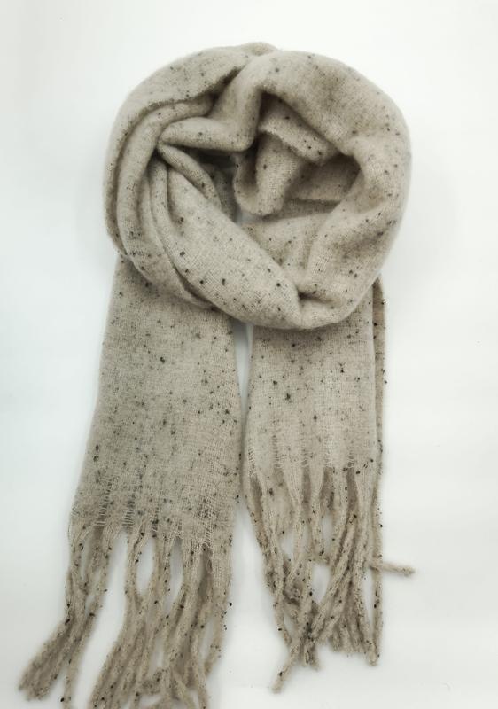 Beige gevlekte gebreide sjaal losjes opgerold met franjes
