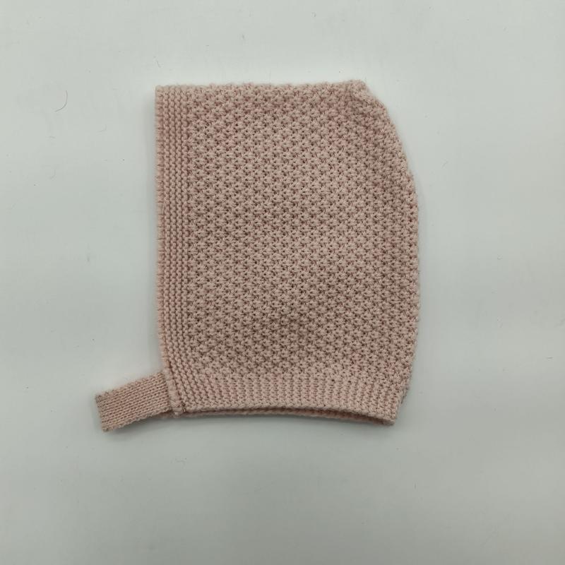 Zachtroze gebreide babymuts met seedsteek textuur en geribbeld kinbandje