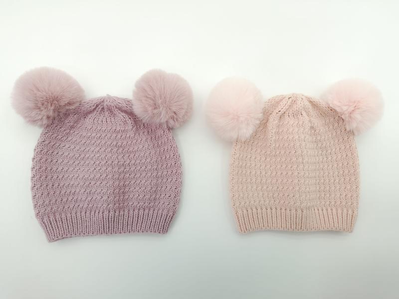 Twee gebreide wintermutsen met dubbele nepbont pompons in mauve paars en blush roze
