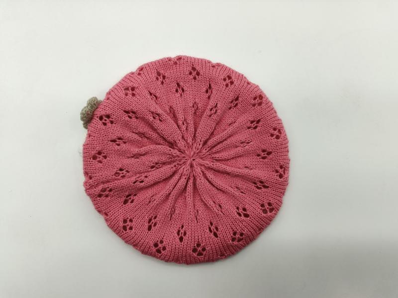 Roze gebreide baret met floraal kantpatroon en kleine beige pompon