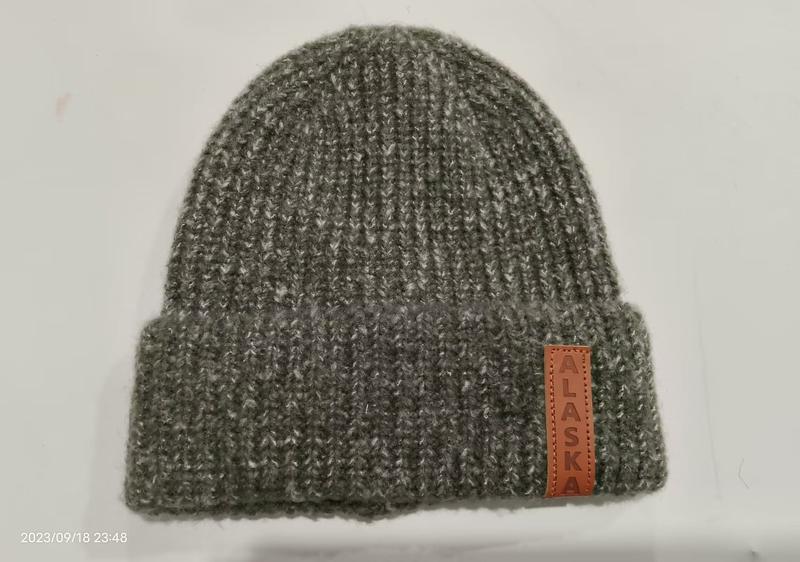 Grijze geribbelde gebreide muts met omslag en Alaska leren label - groothandel winteraccessoires