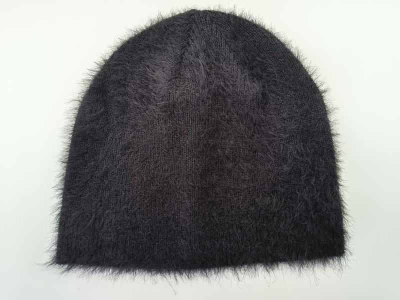 `Donkere antraciet fuzzy gebreide muts van angorastijl met pluizige textuur`