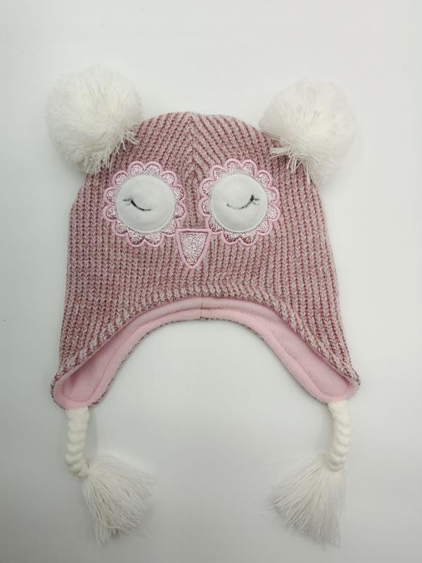 Roze gebreide uilen-muts voor kinderen met pompon en oorflappen.