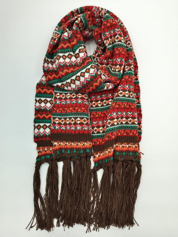 `Rood-groene Fair Isle gebreide sjaal met meerkleurig patroon en bruine franjes aan de uiteinden.`