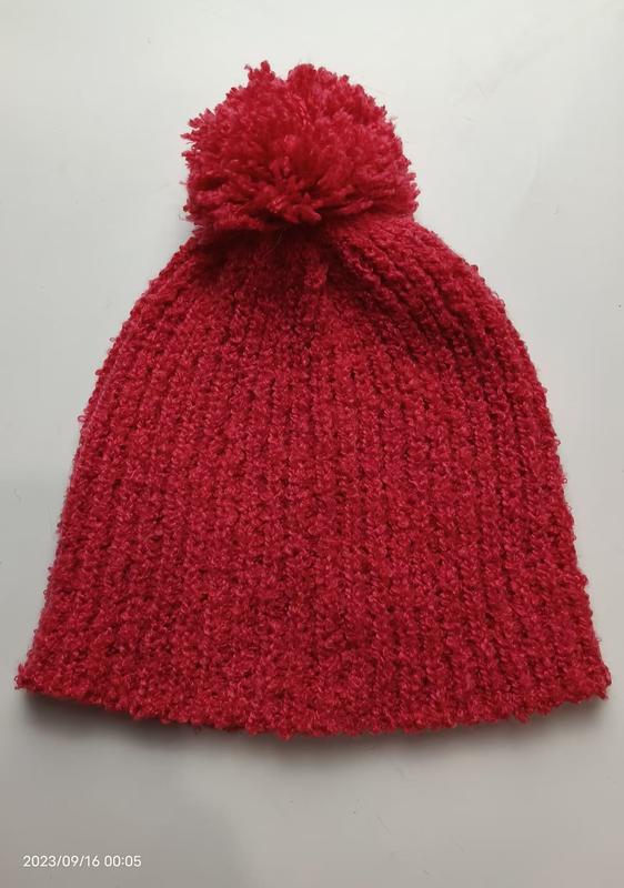 Rode grofgebreide wintermuts met grote pluizige pompon