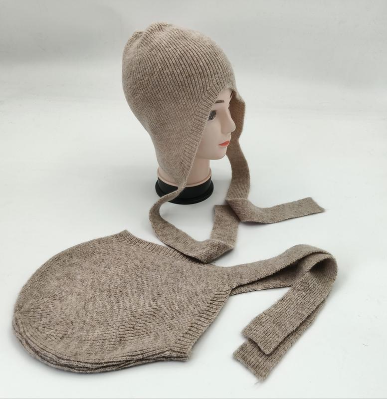 Beige geribde gebreide muts met lange stropdassen op een paspop en platliggend