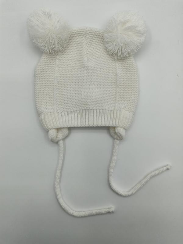 Ivoren gebreide babymuts met twee pluizige pomponnen en lange kinbandjes