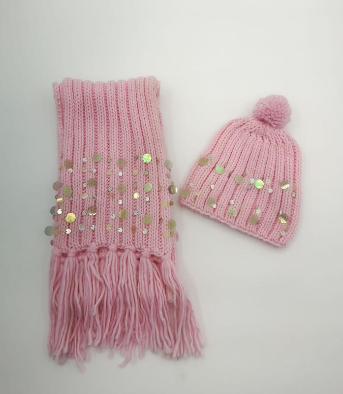 Roze gebreide sjaal met franje en pailletten gecombineerd met bijpassende muts met pompom