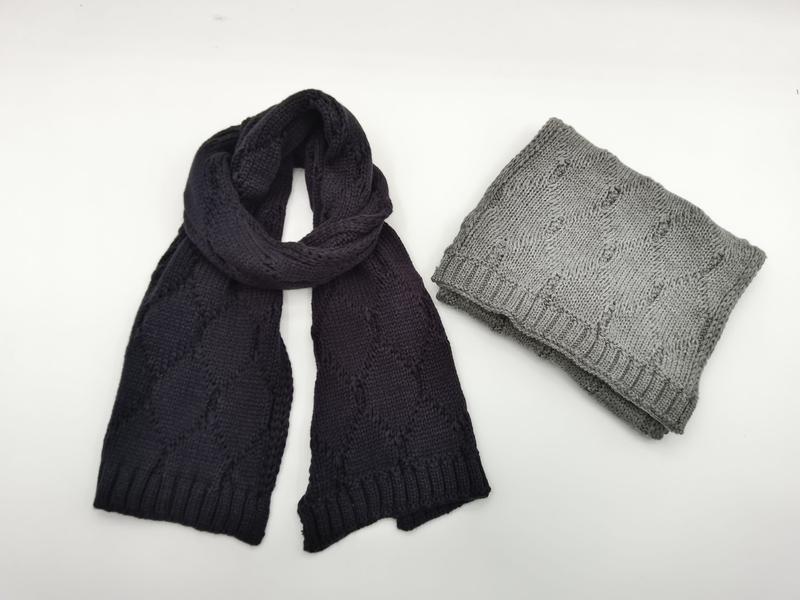 Twee gebreide sjaals op witte achtergrond: marineblauw gedrapeerd en gevouwen grijs met geribbelde randen. 2-pack.