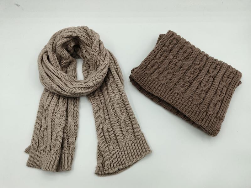 Beige kabelgebreide sjaal en gevouwen bruine nekwarmer snood op witte achtergrond