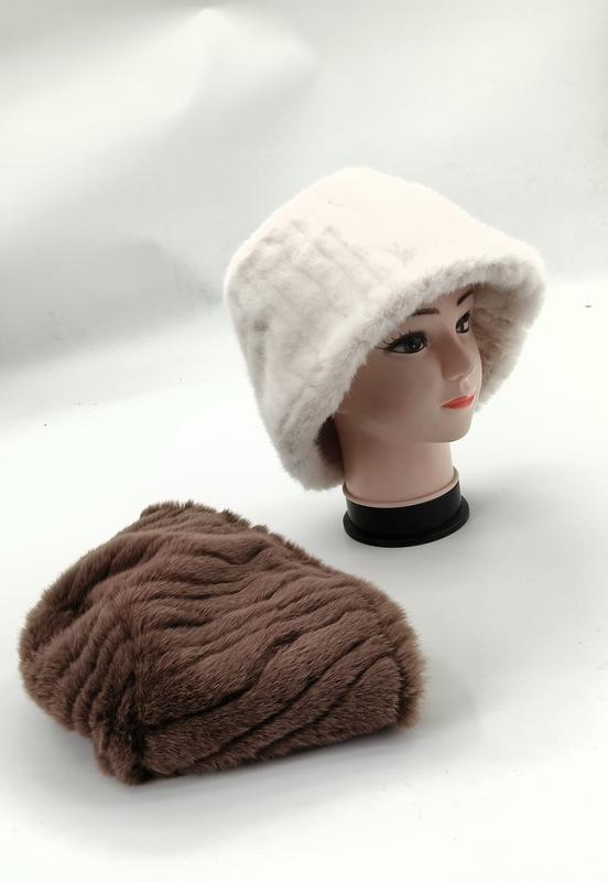Witte faux fur bucket hat op paspop met bruine geribbelde pluche beanie op witte ondergrond.
