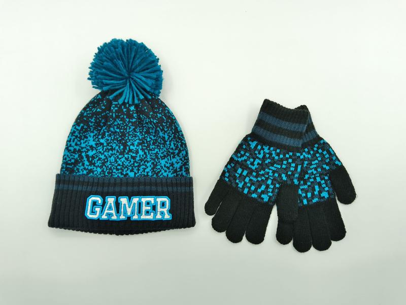 Kinderset met teal-zwarte gebreide gamer muts met pompon en bijpassende pixel handschoenen op witte achtergrond.