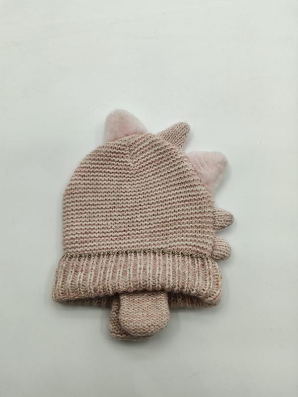 Roze gebreide babymuts met pluizige pompon-eenhoornoortjes en bijpassende wantjes op witte achtergrond.