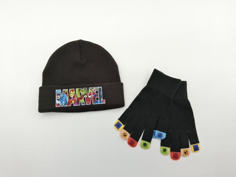 Zwarte gebreide muts met superheld-patch en bijpassende vingerloze handschoenen met kleurrijke heldeniconen.