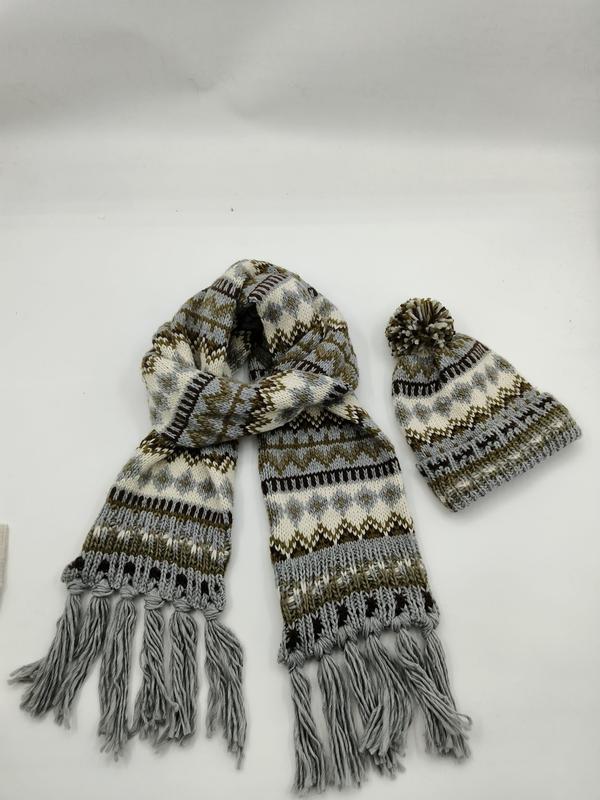 Grijze en bruine Fair Isle gebreide sjaal met franjes en bijpassende pompon muts op witte achtergrond.