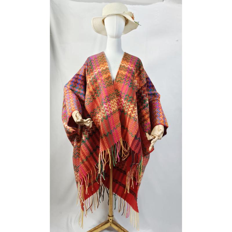 Witte paspop met kleurrijke chevron zigzag geweven poncho met franje zoom en brede zonnehoed.