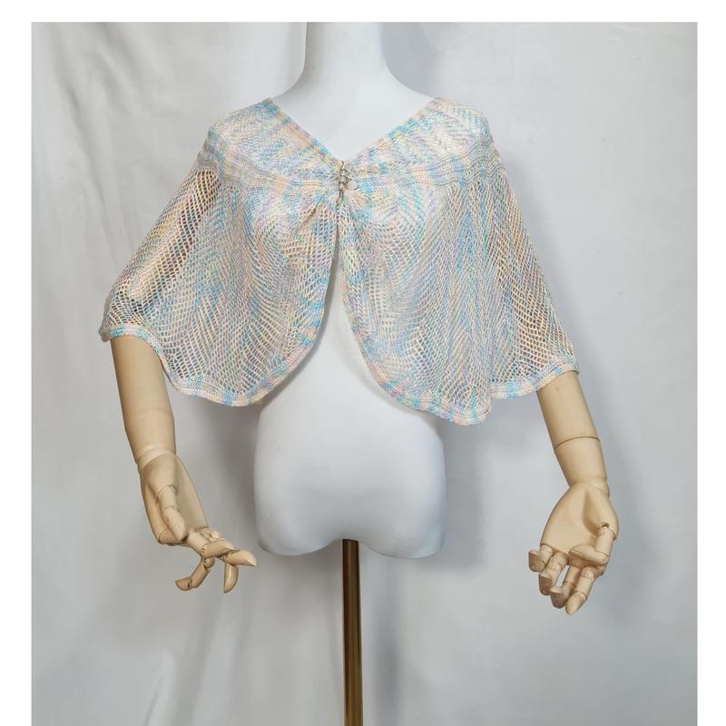 Pastel blauw-roze open-gebreide mesh cape sjaal met strass-sluiting op witte paspop.