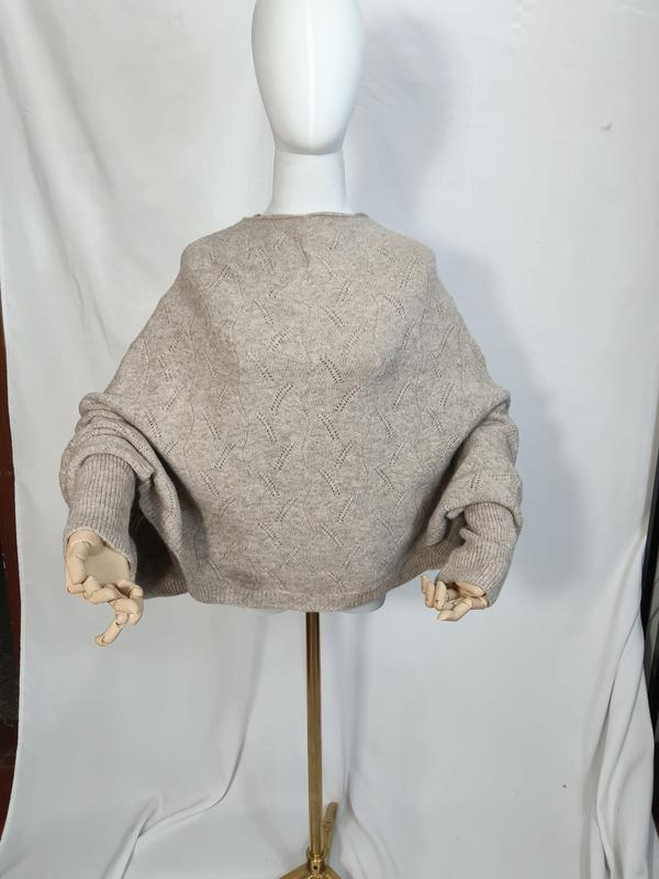 Achterkant oversized havermout beige pointelle gebreide batwing trui met vleermuismouwen op mannequin.