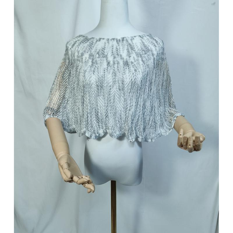 Grijswit open gebreid kant crop poncho cape op paspop met houten handen en geschulpte zoom.