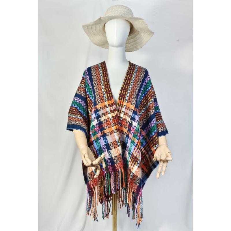 Multicolor boho aztec geometrisch gefranjerd poncho omslagdoek op een mannequin met crème slappe hoed.