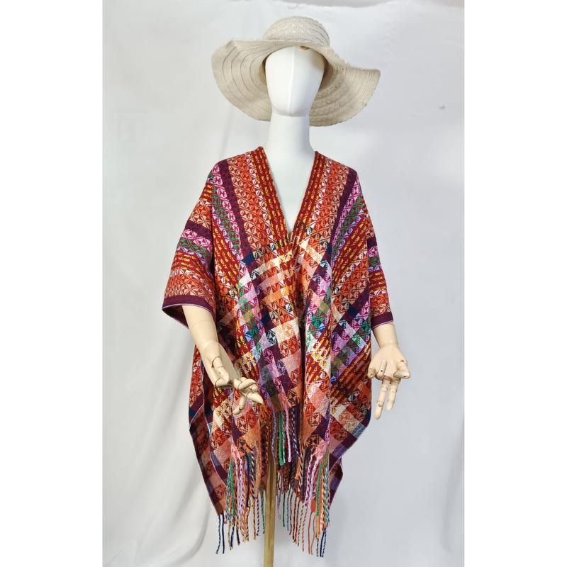 Handgeweven poncho met geometrisch patroon en franjes in meerdere kleuren