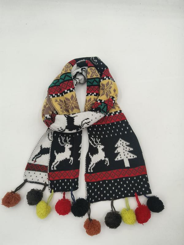 Kleurrijke gebreide wintersjaal met rendieren en kerstbomen in Fair Isle-patroon en veelkleurige pompom-franje.