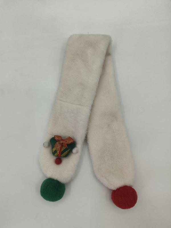 Crème kunstbont sjaal met groene en rode pomponuiteinden en geborduurde kerstbelbroche op witte achtergrond.