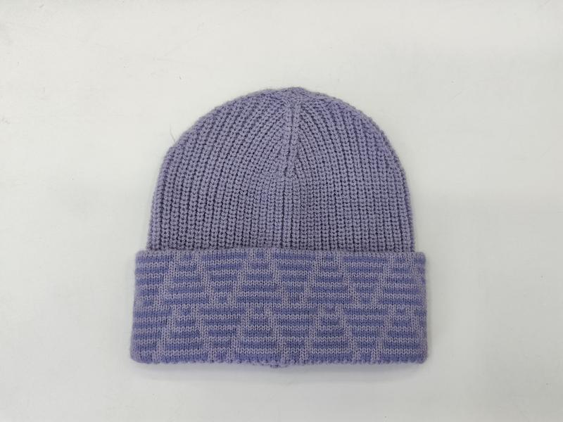 Lavendelkleurige geribbelde gebreide muts met gevouwen jacquard manchet op witte achtergrond.