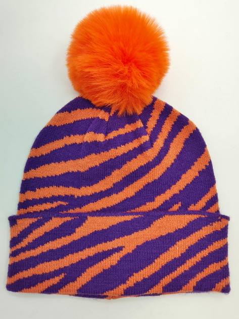 `Gebreide muts met paars-oranje zebrastrepenpatroon en grote oranje pompom van imitatiebont.`