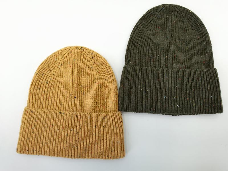 Twee geribbelde beanie mutsen met gespikkeld dessin in mosterdgeel en olijfgroen