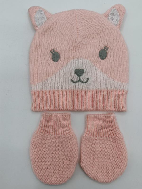 Roze gebreide babymuts met berenmotieven en bijpassende wantjes op witte achtergrond.