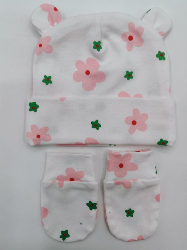 Witte katoenen babymuts met bereoortjes en bijpassende wantjes met roze en groene bloemenprint.