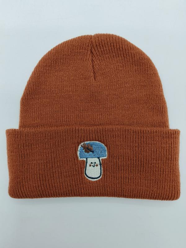 Roestoranje geribbelde gebreide beanie met omgeslagen rand en blauw-wit geborduurd paddenstoelpatroon.