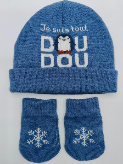 Blauwe gebreide babymuts en wantjes set met pinguïn en sneeuwvlok motief op lichte achtergrond.