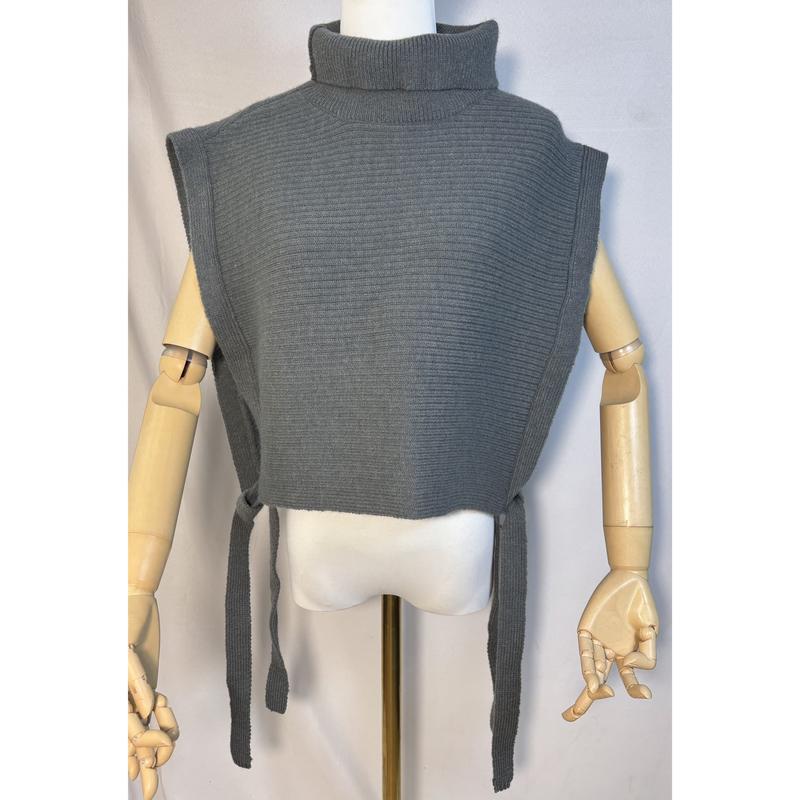 Grijze ribgebreide mouwloze coltrui-vest met zijdelingse striksluitingen op een houten paspop.