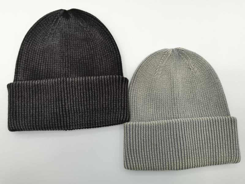 Twee geribbelde gebreide beanie mutsen met omslag naast elkaar