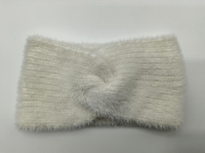 Crèmekleurige pluizige gebreide hoofdband met gedraaide knoop in het midden