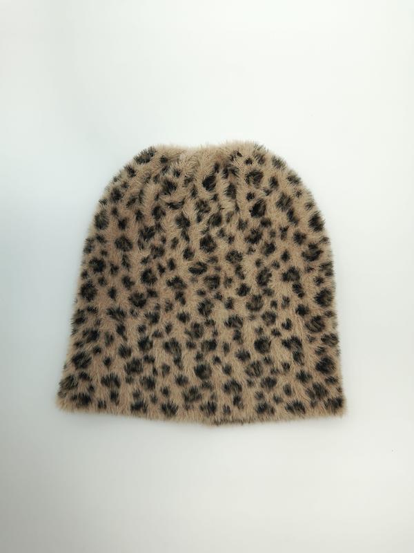 Platte bovenaanzicht van een beige en donkerbruine luipaardprint pluizige gebreide muts op witte achtergrond.