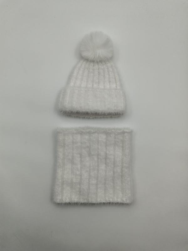 Witte geribbelde gebreide wintermuts met imitatiebont pompon en bijpassende nekwarmer set op grijze achtergrond.