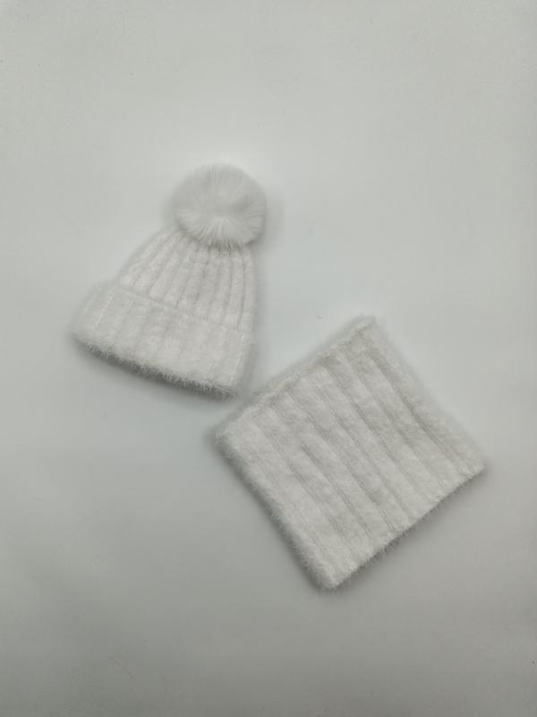 Witte ribgebreide muts met pompon en bijpassende nekwarmer set op witte achtergrond.