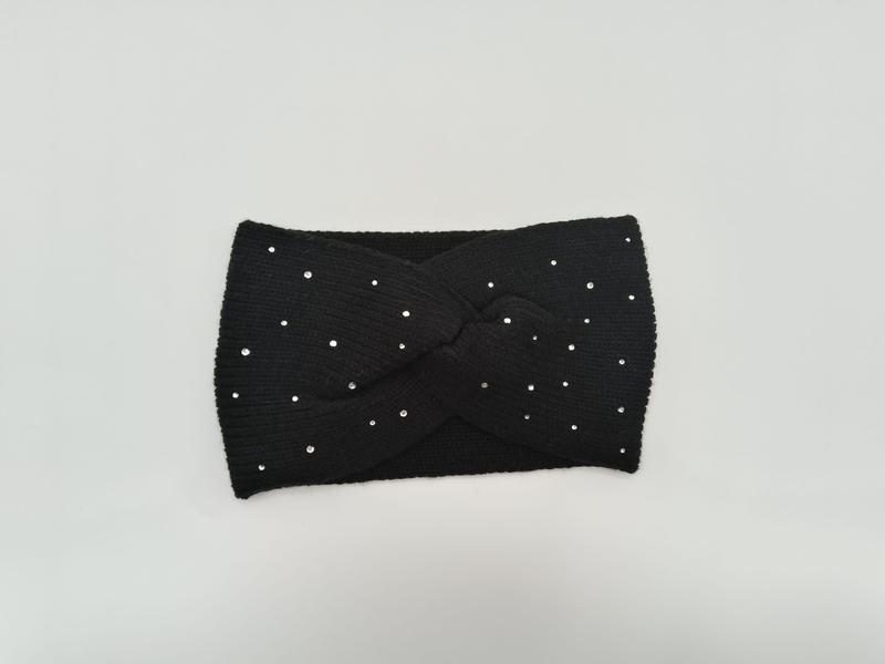 Zwarte geribde gebreide haarband met gedraaid design en verspreide zilveren kristallen strass-steentjes op witte achtergrond.