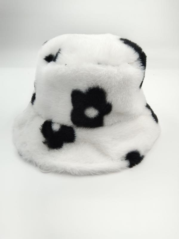 Witte pluizige faux fur bucket hat met zwart madeliefjespatroon en zachte pluche textuur