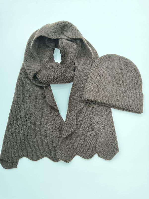 Taupe geribde gebreide wintersjaal met geschulpte zoom en bijpassende beanie muts set op lichte achtergrond.